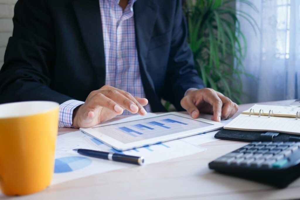 Financial professional reviewing portfolio charts on a tablet at a desk