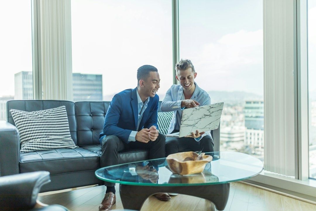 Two professionals reviewing a document in a bright office lounge